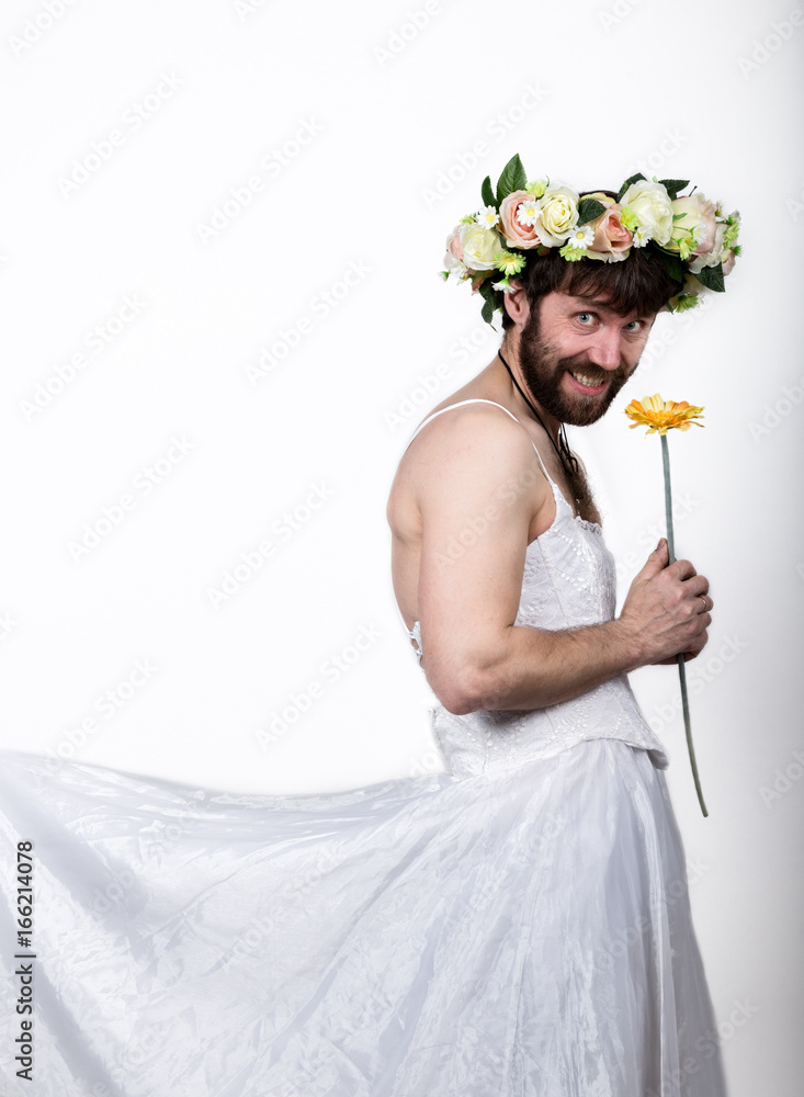 bearded man in a woman's wedding dress on her naked body, holding a flower.  on his head a wreath of flowers. funny bearded bride Stock Photo | Adobe  Stock