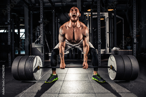 Muscular men lifting deadlift photo