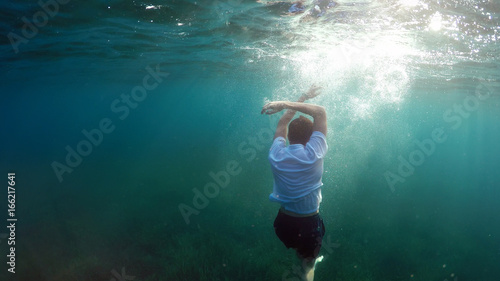 young man sinking into the sea