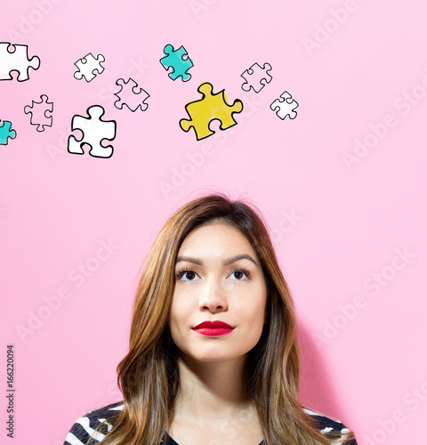 Puzzle with young woman on a pink background