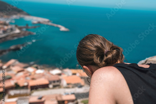Brunette woman looking over old italian town. Sardinia. Italy.