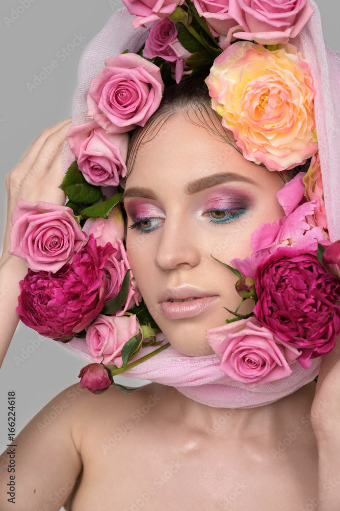 Studio portrait of a beautiful young woman. Fashionable brunette model with nude pink lips and perfect colorfull makeup in scarf on head Studio portrait of a beautiful young woman. Fashionable brunette model with nude pink lips and perfect colorfull makeup in scarf on head