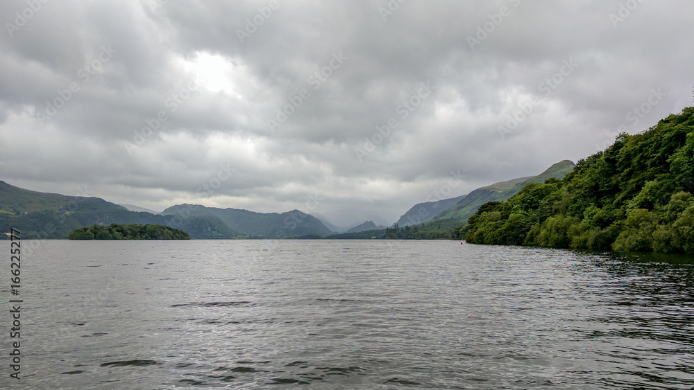 Cloudy landscape of a lake with mountains in the background
