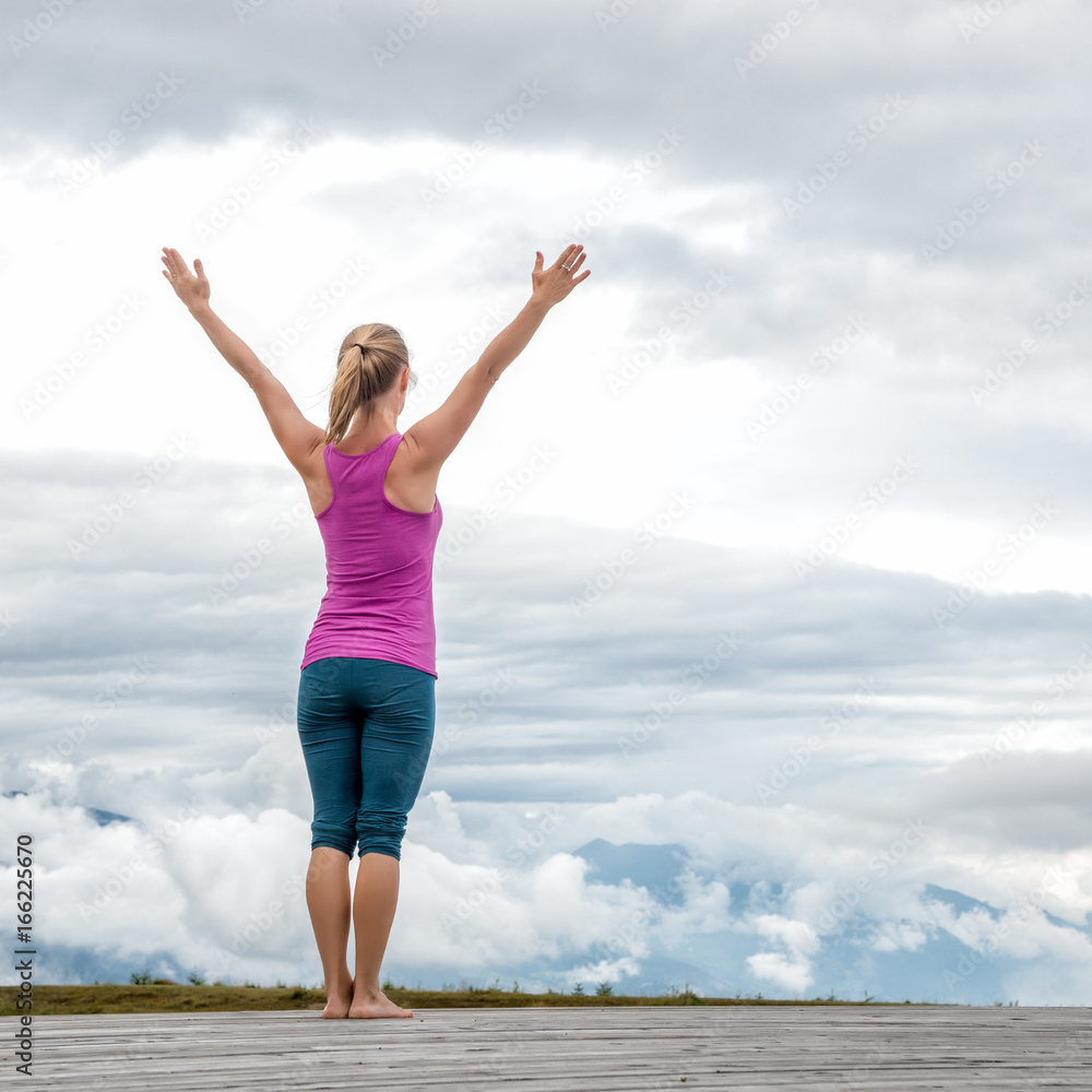 young woman meditate on top of the mountain young woman meditate on top of the mountain