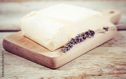Butter on a wooden chopping board decorated with lavender