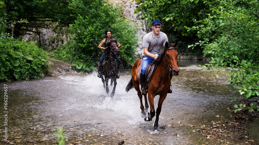 Group of friends riding horses on the river Group of friends riding horses on the river