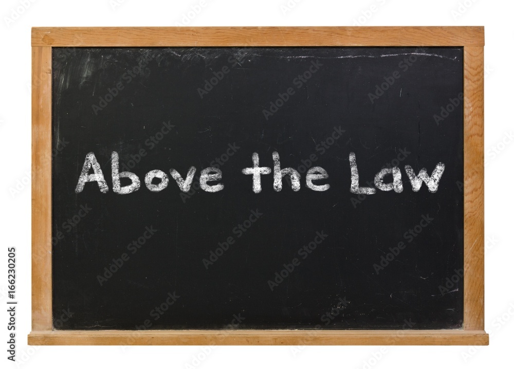 Above the law written in white chalk on a black chalkboard isolated on white Above the law written in white chalk on a black chalkboard isolated on white