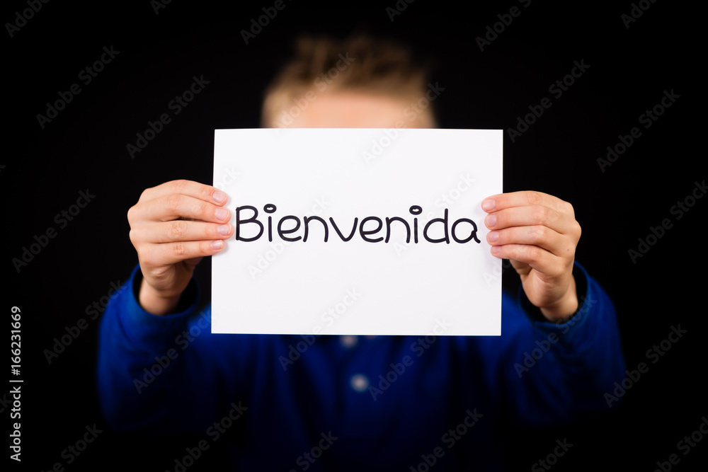 Child holding sign with Spanish word Bienvenida - Welcome Child holding sign with Spanish word Bienvenida - Welcome