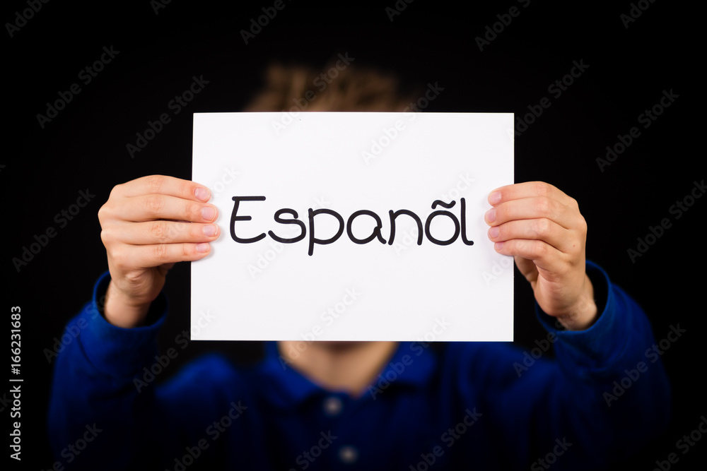 Child holding sign with Spanish word Espanol - Spanish in English Child holding sign with Spanish word Espanol - Spanish in English