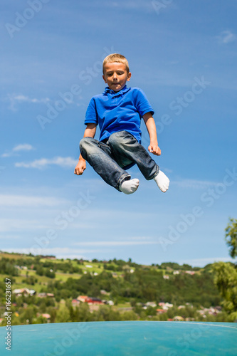 Young boy jumping on trampoline © Mikkel Bigandt