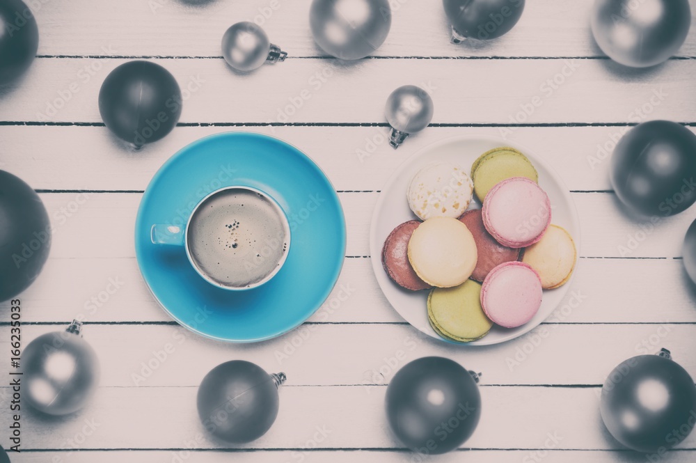 Cup of coffee and macaron with christmas toys on whte background.