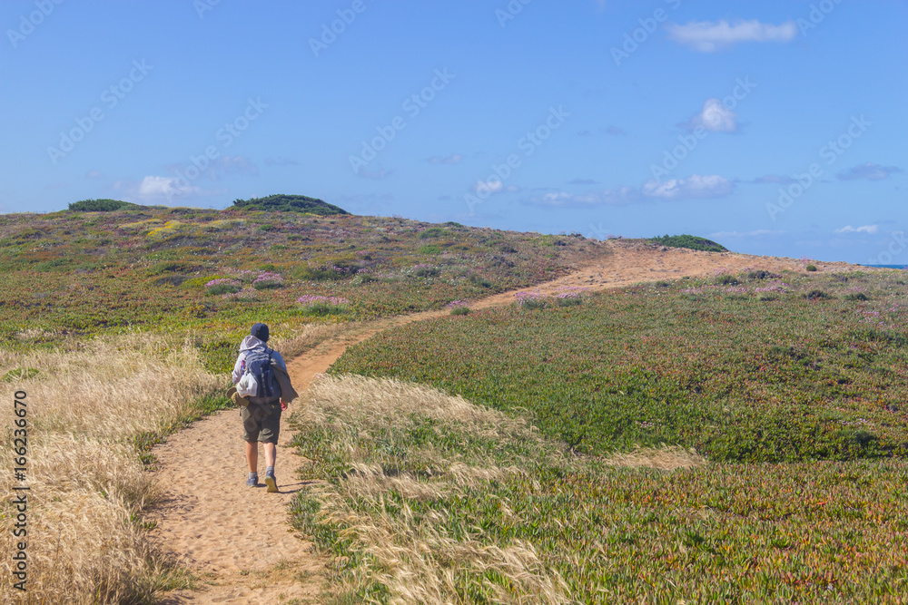 Girl hiking in Trail over the cliffs in Porto Covo