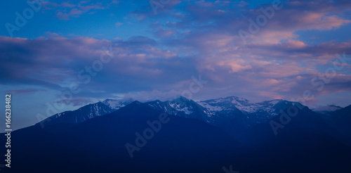 Photo depicting beautiful a foggy mystic mountains. Fog clouds at the pine tree mystical woods, morning. Europe, Bulgaria, mysterious Balkan landscape.