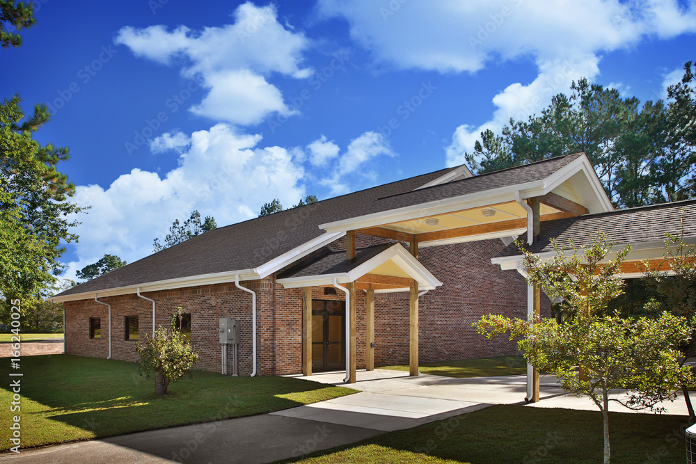 Generic Brick Rec Hall Recreational Building Exterior With Roofed patio and green landscaping during day