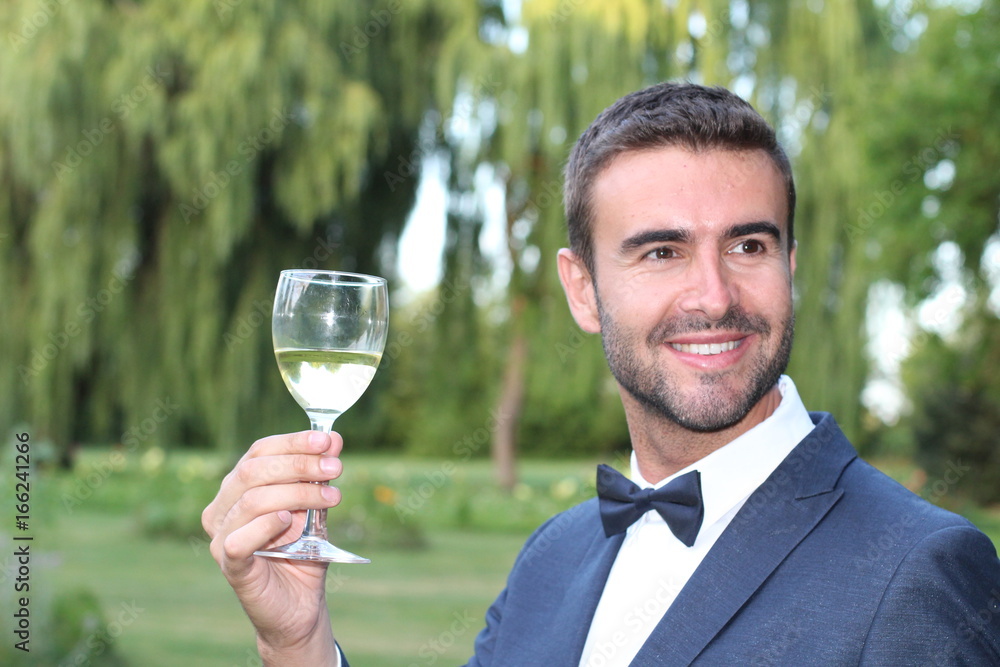 Striking man drinking white wine outdoors Striking man drinking white wine outdoors