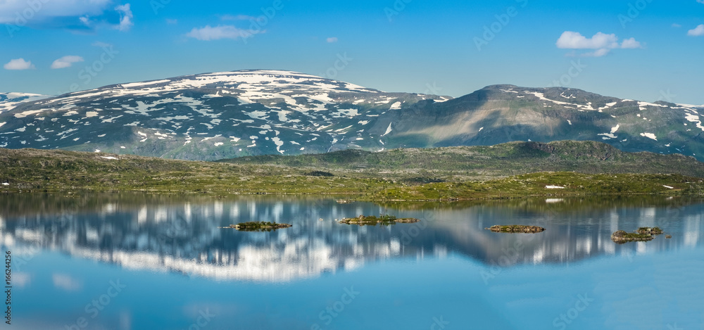 Scenic mountain reflection with calm lake at bright summer day in Abisko, Sweden