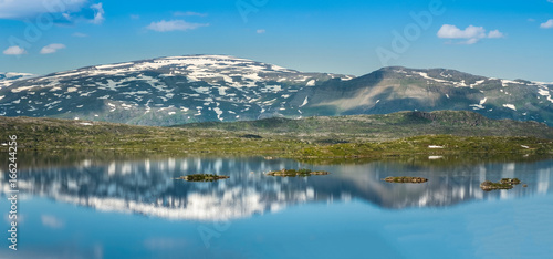 Scenic mountain reflection with calm lake at bright summer day in Abisko, Sweden