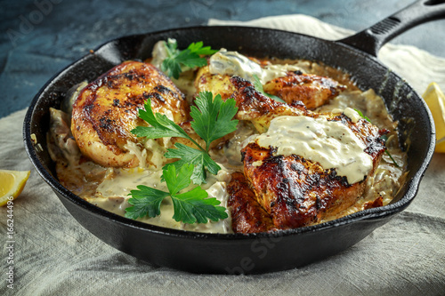 Fotografie Creamy chicken fellets supremes in mushroom sauce with parsley In rustic cast iron skillet
