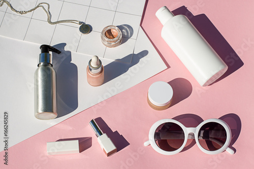 Summer pink cosmetics flat lay with sunglasses . Top view beauty composition