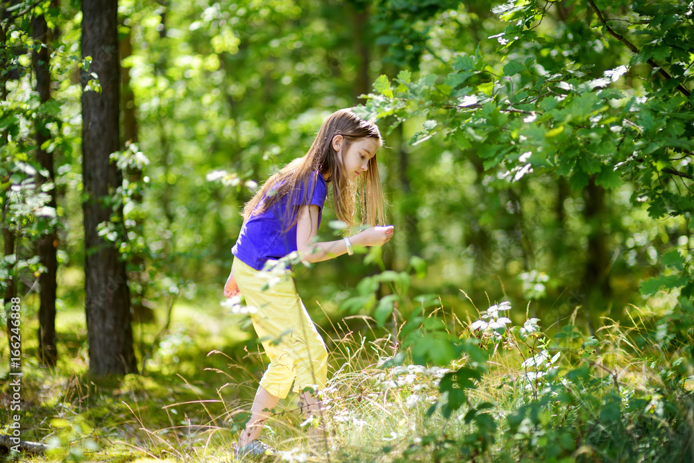 Cute little girl having fun during forest hike on beautiful summer day Cute little girl having fun during forest hike on beautiful summer day
