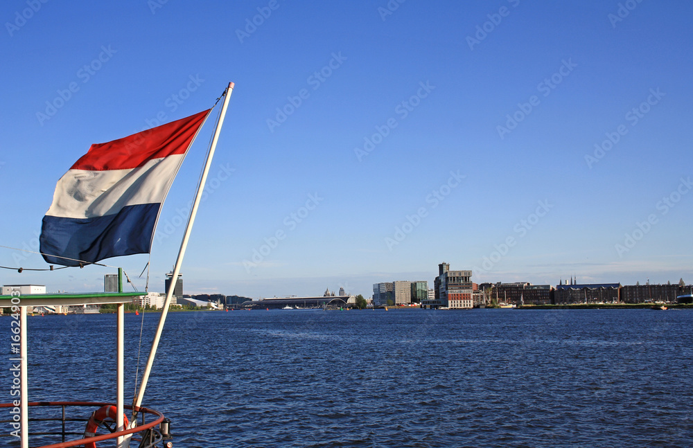 Harbour view of Amsterdam with a flag of the Netherlands
