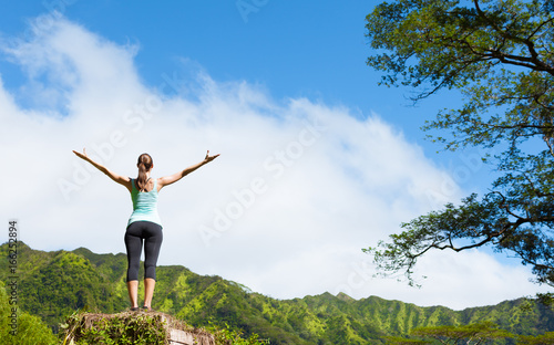It's a beautiful life! Happy woman in a beautiful mountain nature setting with her arms up in the air. 