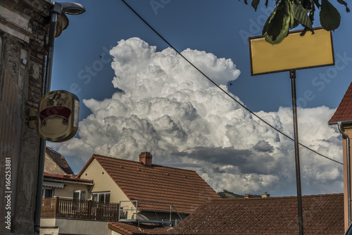 Big white clouds over roofs of Prackovice village