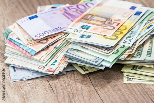 Pile money: dollars and euros banknotes on desk