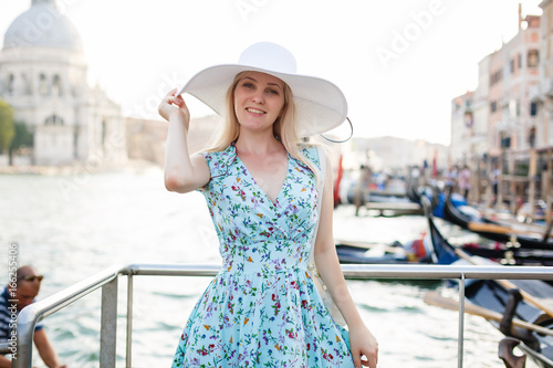 Woman tourist travel in Italy. Young girl with a white hat in venice on an old street. Girl traveling to Venice. © Angelov