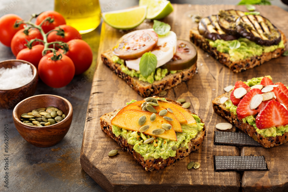 Variety of avocado toasts on a cutting board Variety of avocado toasts on a cutting board
