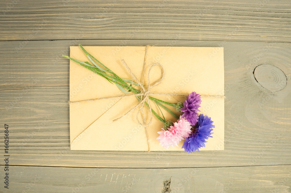 Obraz premium envelope with flowers on wooden background