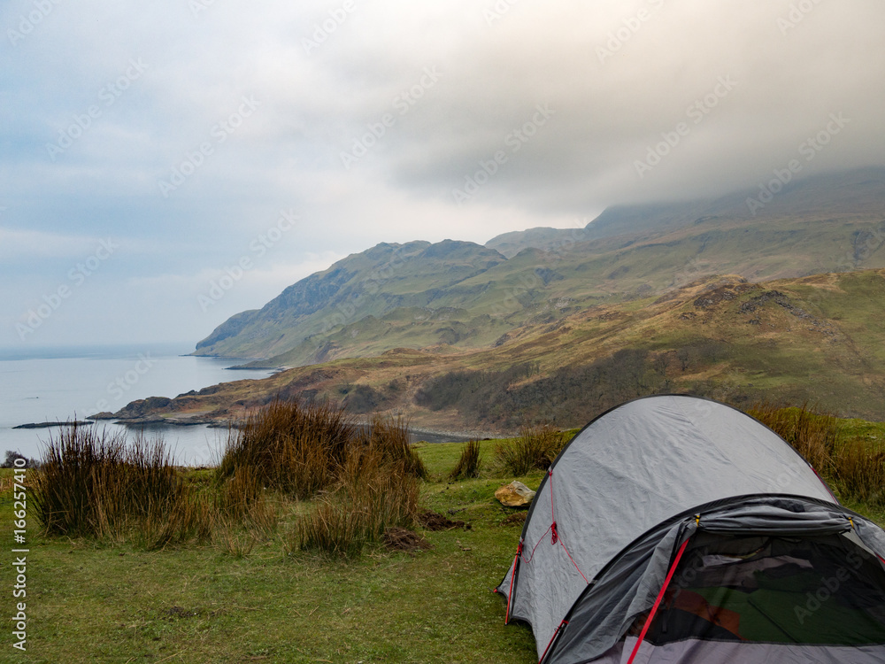 Grey tent in front of a bay in Scotland