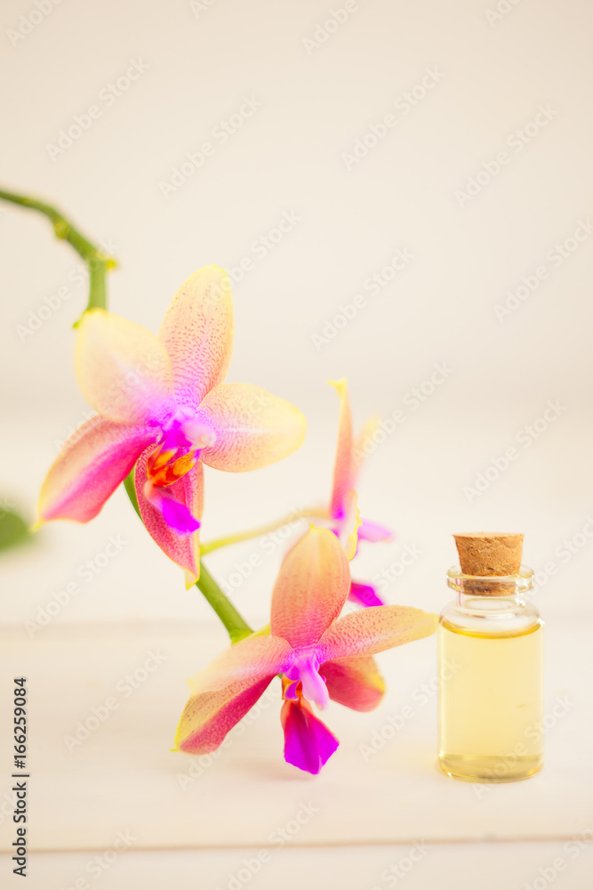 Essence of orchid flowers on table in beautiful glass jar Essence of orchid flowers on table in beautiful glass jar