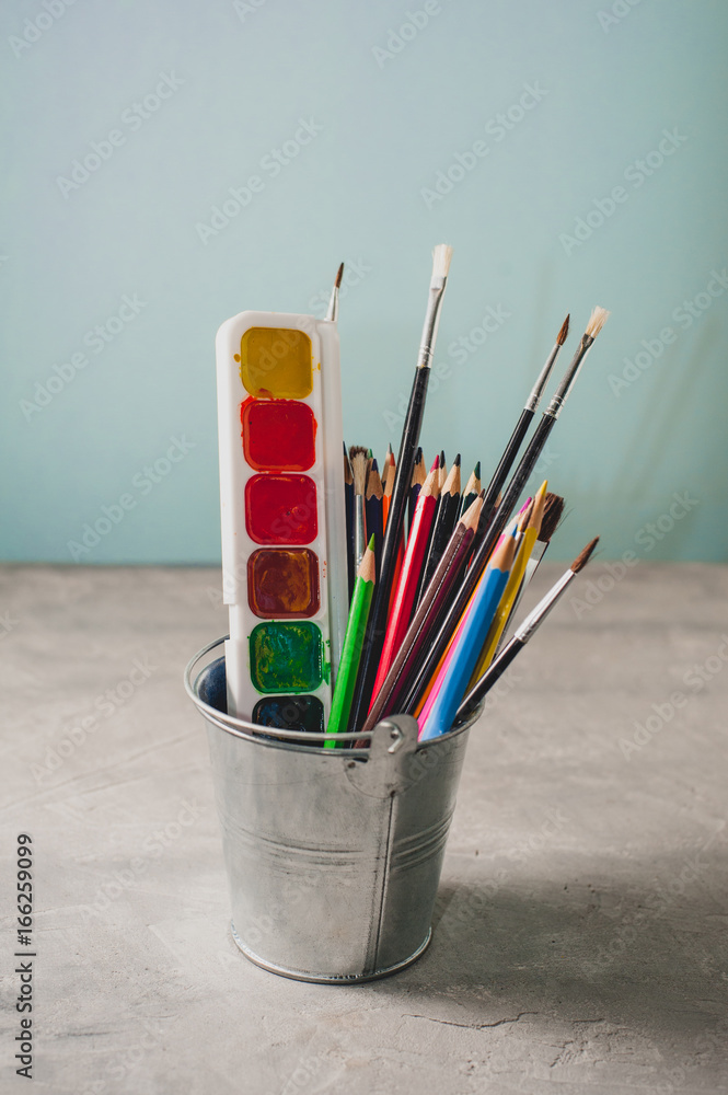 Obraz premium Drawing accessories - pencils, paints and brushes on a gray background