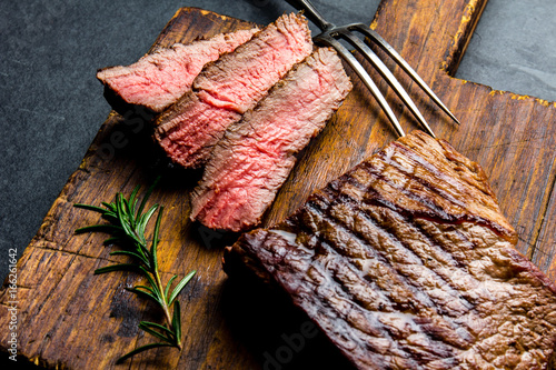 Картината върху платно Sliced grilled medium rare beef steak served on wooden board Barbecue, bbq meat beef tenderloin