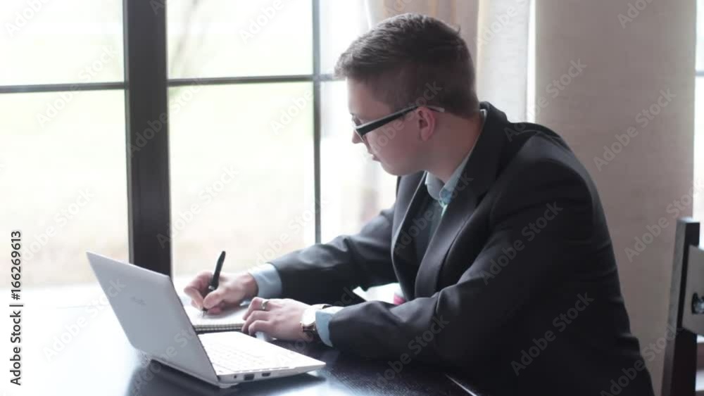 Financial Strategy. Man working on the laptop and doing financial strategy in cafe. Financial Strategy. Man working on the laptop and doing financial strategy in cafe.