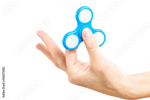 Closeup female hand holding fidget spinner with thumb. Popular antistress toy for relaxing.