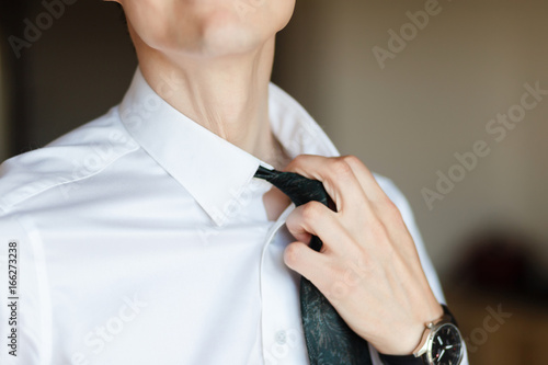 Nervously adjusting his shirt collar . Portrait of anxious businessman loosening his necktie.