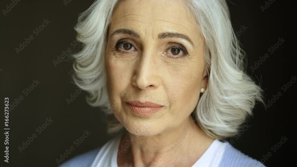 Close up portrait of beatiful old woman with grey hair smiling at camera. Indoor shot. Portrait shot. Close up portrait of beatiful old woman with grey hair smiling at camera. Indoor shot. Portrait shot.