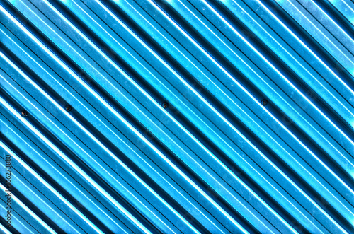 Abstract background closeup of blue diagonal metal lines on material with pattern and texture