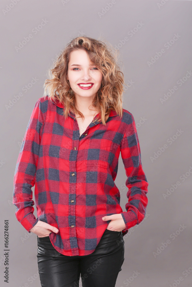 Young woman standing, isolated on gray background. Young woman standing, isolated on gray background.