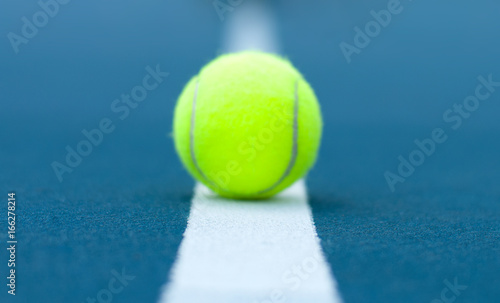 Tennis ball on tennis court with white line © Dmytro Flisak