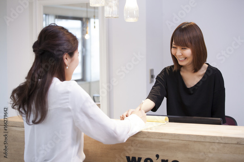 Women are talking at reception desk