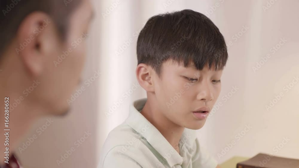 Asian frustrated teenage boy blurring to his father at home Asian frustrated teenage boy blurring to his father at home