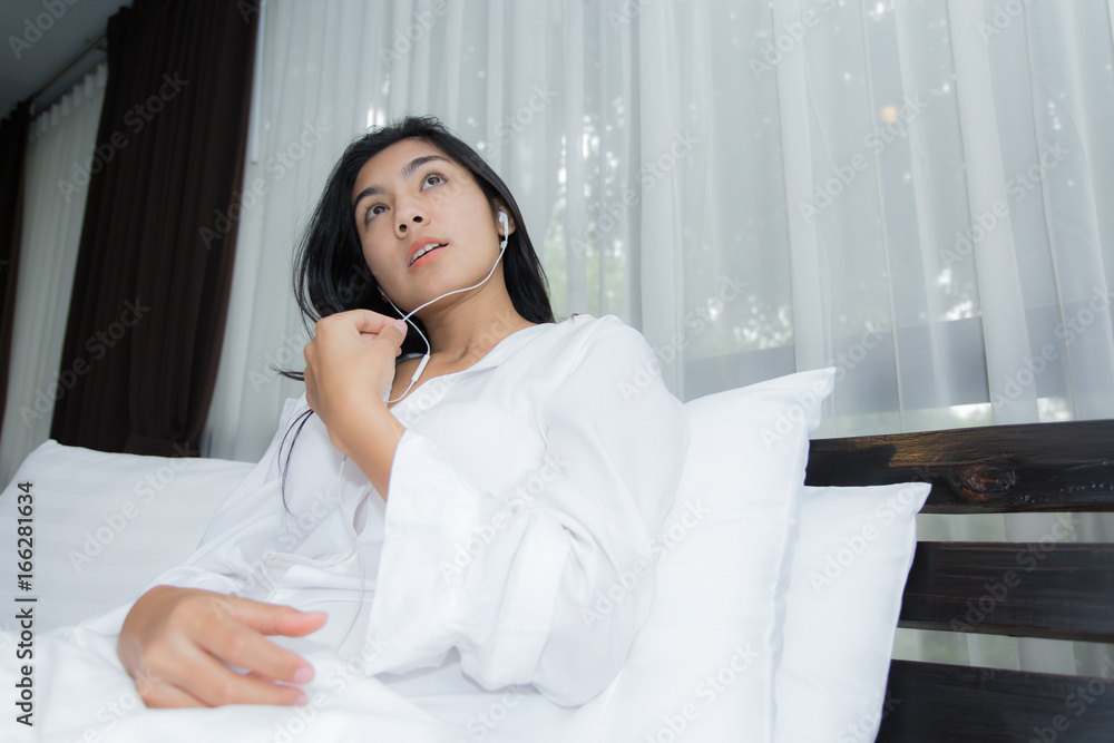 Woman with headphones relaxing on the bed Woman with headphones relaxing on the bed