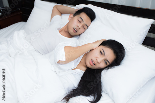 Couple in bed, man snoring on the bed in the bedroom photo