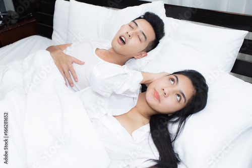 Couple in bed, man snoring on the bed in the bedroom