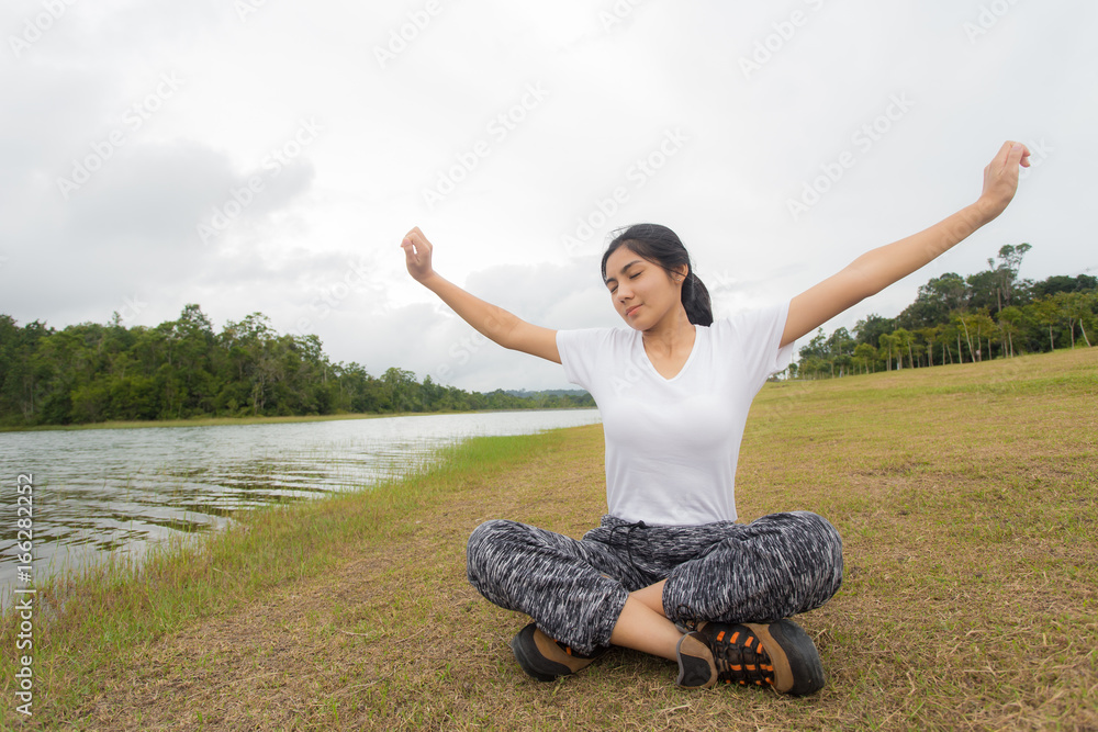Young asian woman enjoying and relaxing on the green grass Young asian woman enjoying and relaxing on the green grass