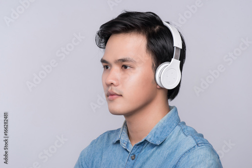 Portrait of an asian man wearing headphones, looking away