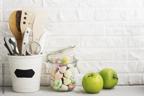 Kitchen still life on a white brick wall background: various cutting boards, tools, greens for cooking, fresh vegetables. Selective focus. photo